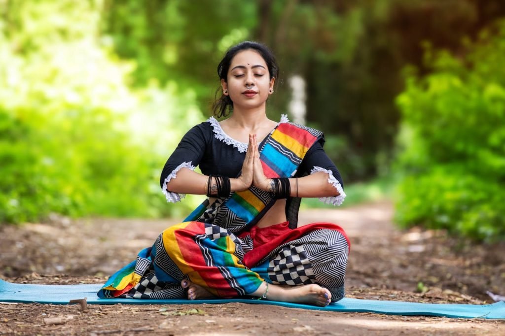 Woman practicing yoga outdoors in colorful attire, embracing mindfulness and inner peace.